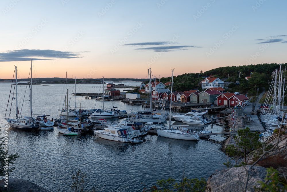 View into the sailing and fishing harbour of Resö during sunset, western Sweden.