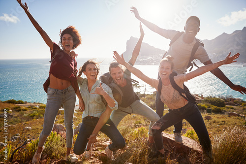 Canvas Print Millennial friends on a hiking trip reach the summit and have fun posing for pho