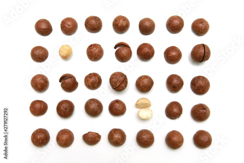 Shelled and unshelled macadamia nuts on white background.