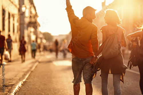 Young couple holding hands while going to a music festival