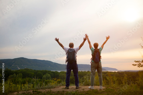 elderly couple on the top of mountain with hands up. Senior couple walking in nature. travel tourism concept