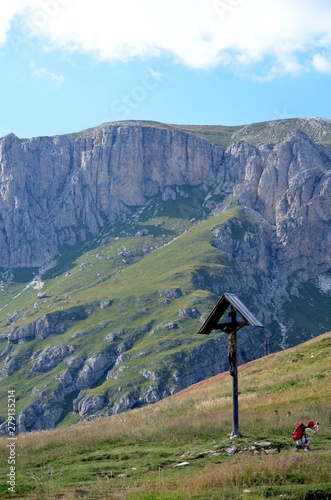 Wooden crucifix in a meadow mountain