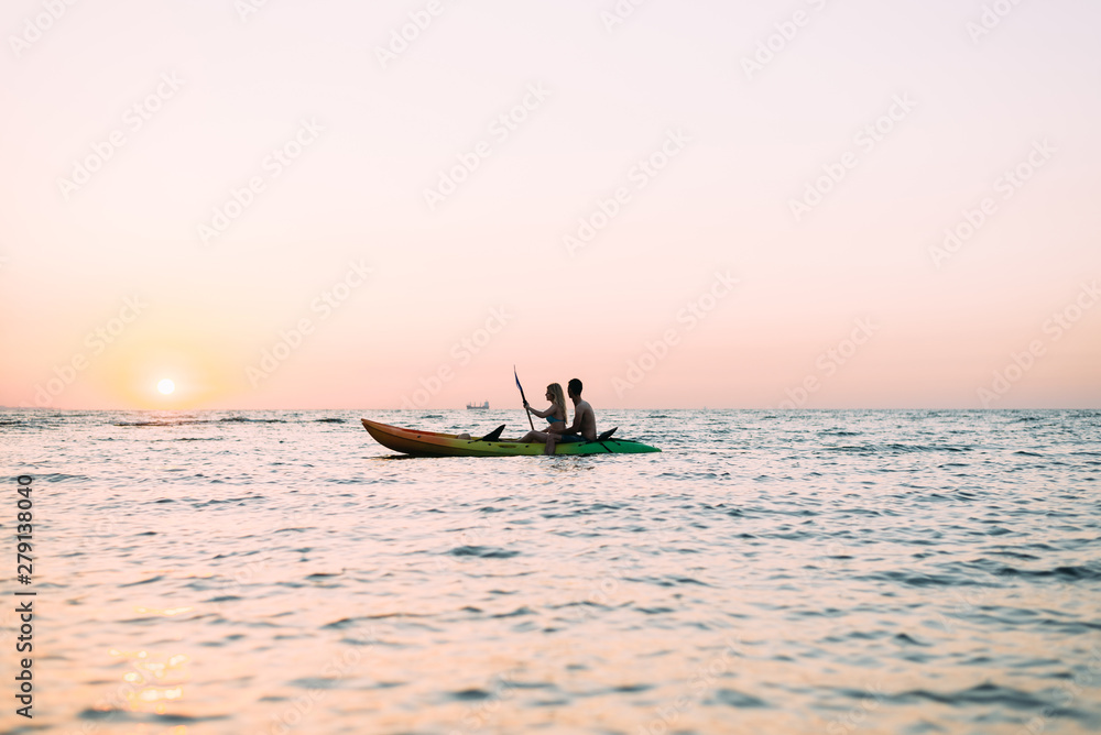 Naklejka premium kayaks active lifestyle, a couple in love man and woman meet the dawn on the ocean