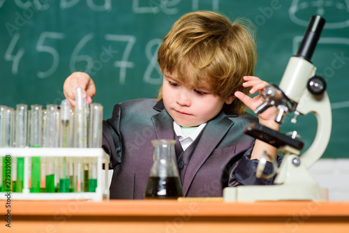 Chemical analysis. Toddler genius baby. Boy use microscope and test tubes in school classroom. Science concept. Gifted child and wunderkind. Kid study chemistry school lesson. School education