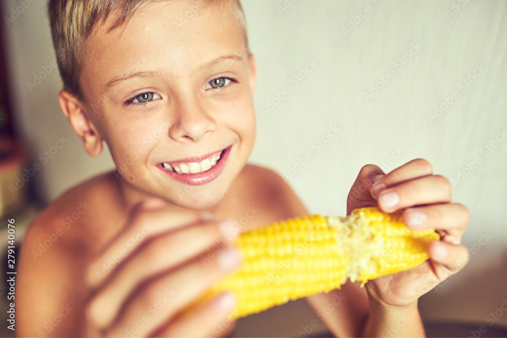 Hungry child with a corncob in his hands Hungry child with a corncob in his hands