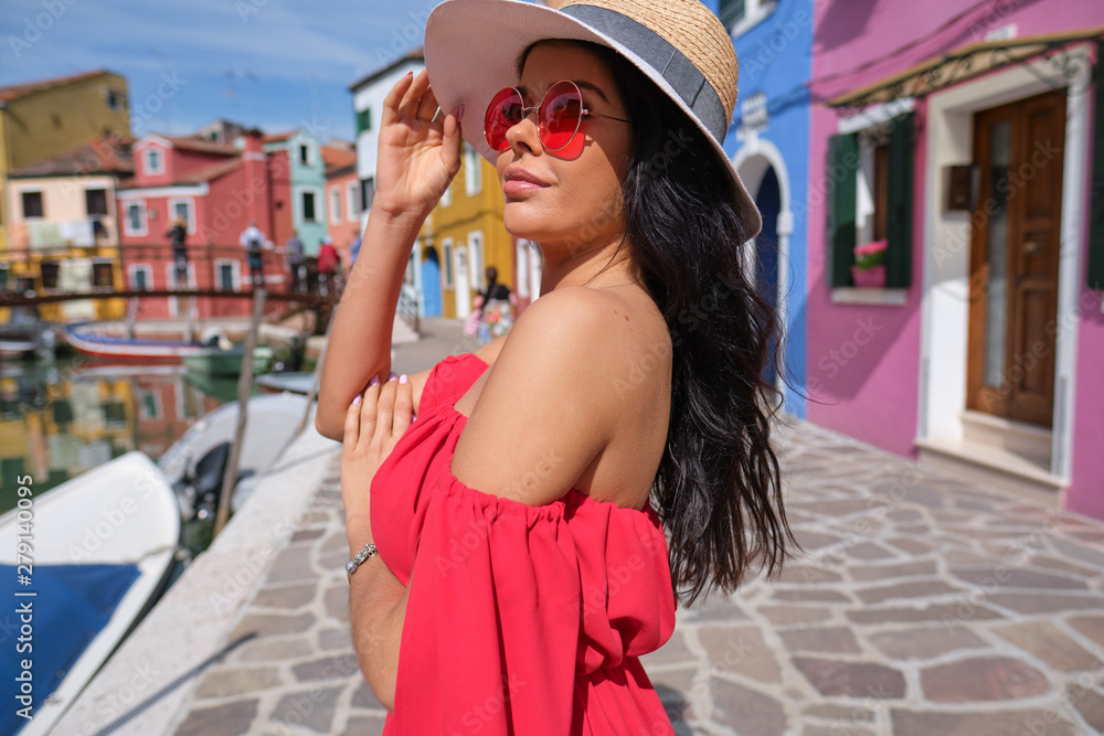 tourist woman posing among colorful houses on Burano island, Venice. Tourism in Italy concept