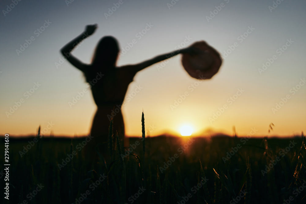 silhouette of young woman in wheat field