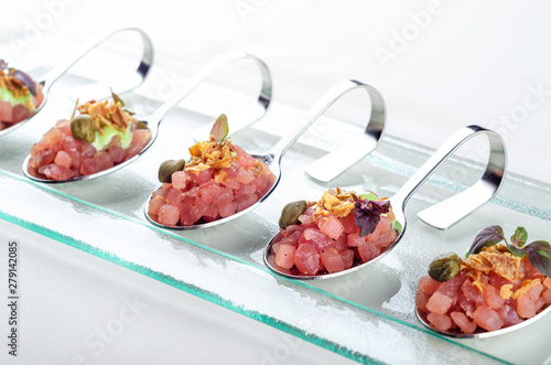 Top view catering banquet table with cold snacks. Raw tuna Tartare decorated capers, close up. Dishes in the restaurant. easy food for guests. Party food.