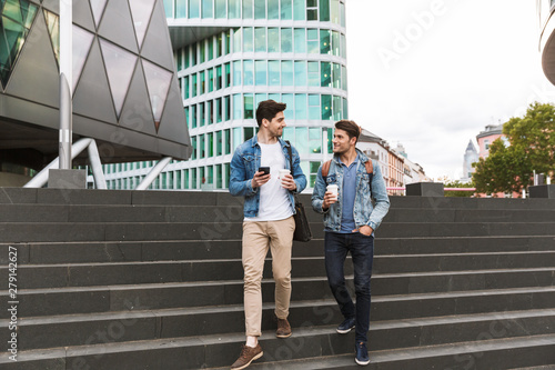 Two smiling young men friends dressed casually