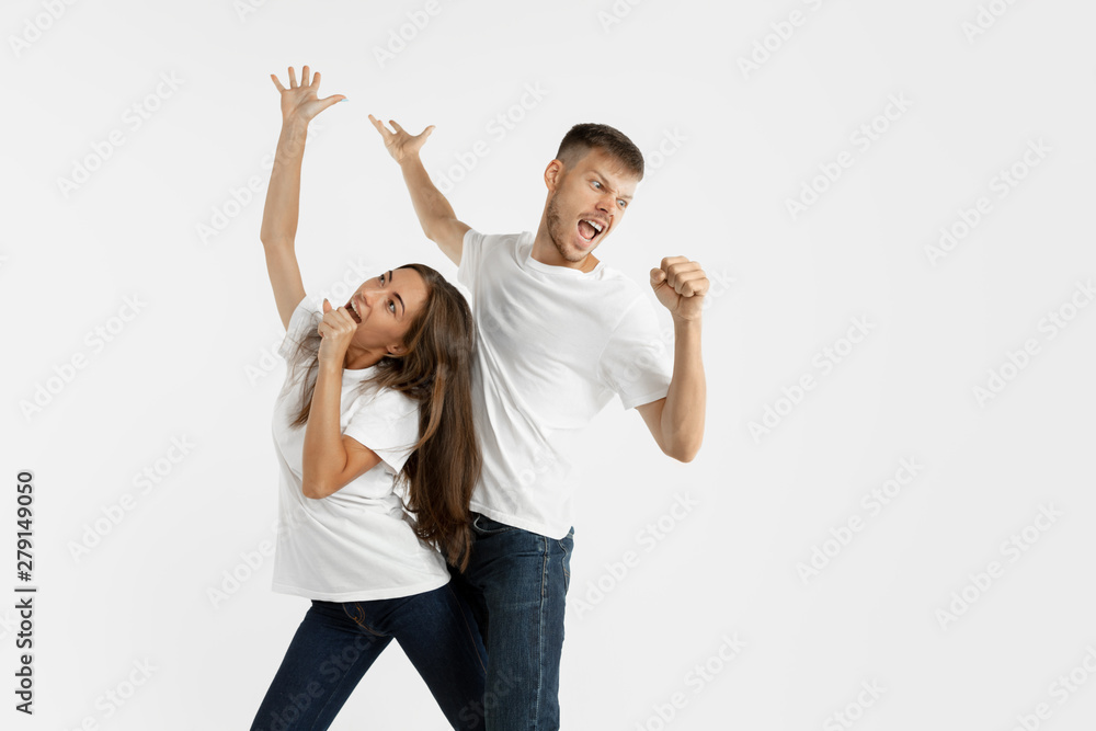 Beautiful young couple's portrait isolated on white studio background. Facial expression, human emotions, advertising concept. Copyspace. Woman and man dancing and singing, look happy together. Beautiful young couple's portrait isolated on white studio background. Facial expression, human emotions, advertising concept. Copyspace. Woman and man dancing and singing, look happy together.