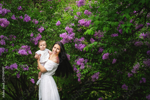 mother with a baby on a walk in the spring flowering garden