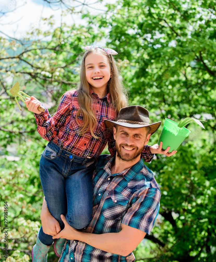 Fototapeta premium Transplanting vegetables from nursery or gardening center. Maintain garden. Planting flowers. Family dad and daughter planting plants. Plant your favorite veggies. Planting season. Family garden