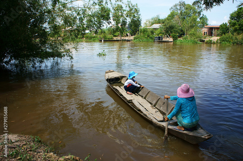 Vietnamese woman transport little girl go to school by wooden boat © xuanhuongho