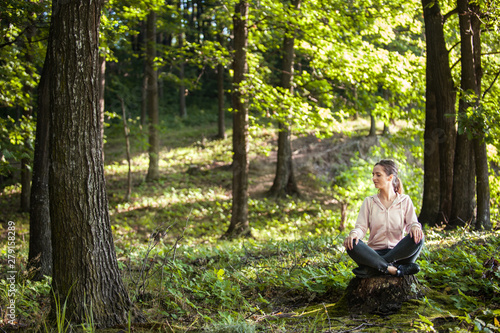 Beautiful woman meditating in the forest on a sunny morning © xpabli