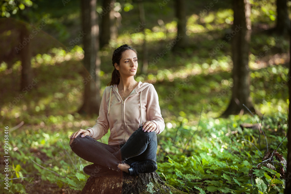 Beautiful woman meditating in the forest on a sunny morning Beautiful woman meditating in the forest on a sunny morning