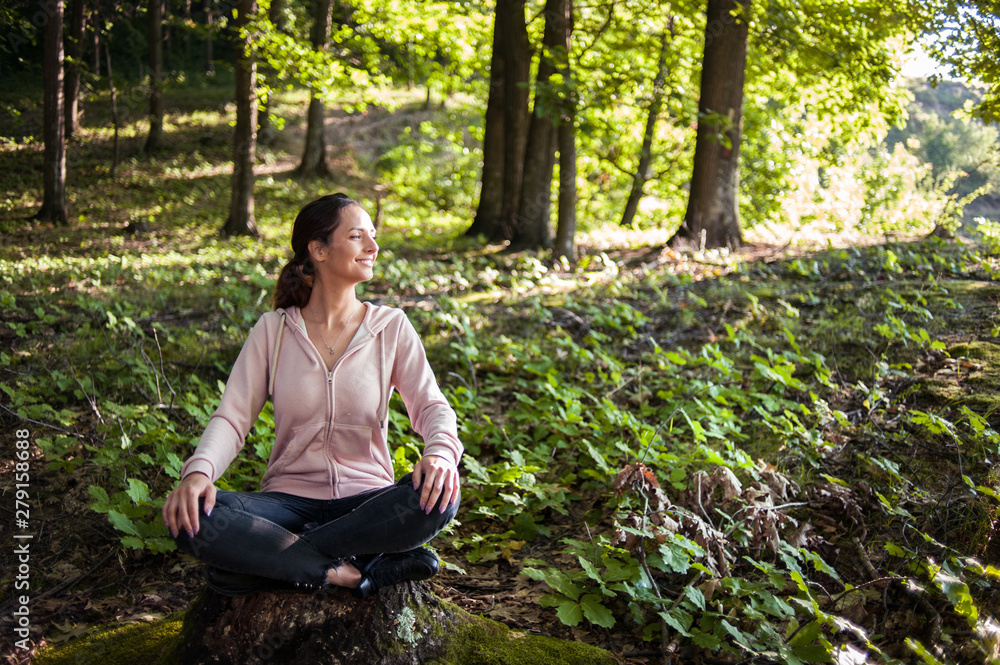 Beautiful woman meditating in the forest on a sunny morning Beautiful woman meditating in the forest on a sunny morning