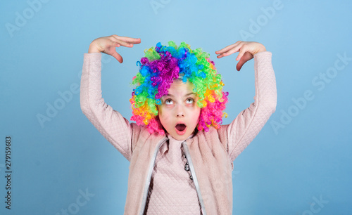 Acting school for children. Develop acting talent into career. Girl artistic kid practicing acting skills. Kid colorful curly wig artificial hair clown style blue background. Circus school concept