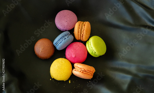 Colorful macarons on black background, close up view photo