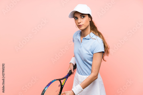 Young tennis player woman over isolated pink wall © luismolinero