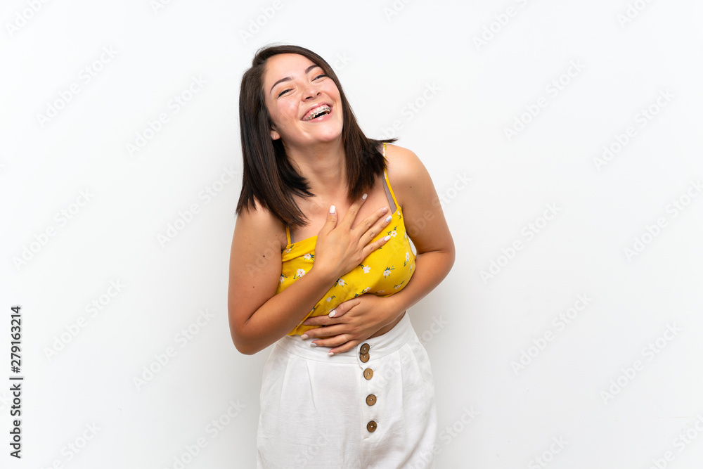 Young Mexican woman over isolated wall smiling a lot Young Mexican woman over isolated wall smiling a lot