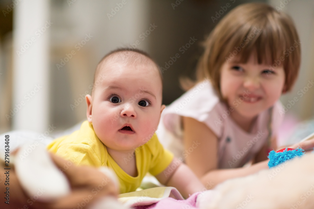little sister and her baby brother playing at home little sister and her baby brother playing at home