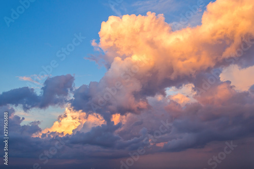 big fluffy yellow and blue clouds in bright blue sky