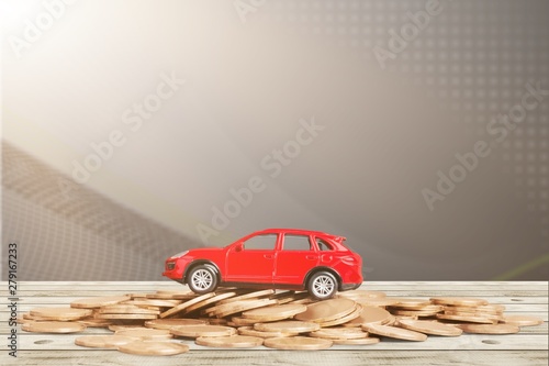 Golden coins and toy car on  background © BillionPhotos.com