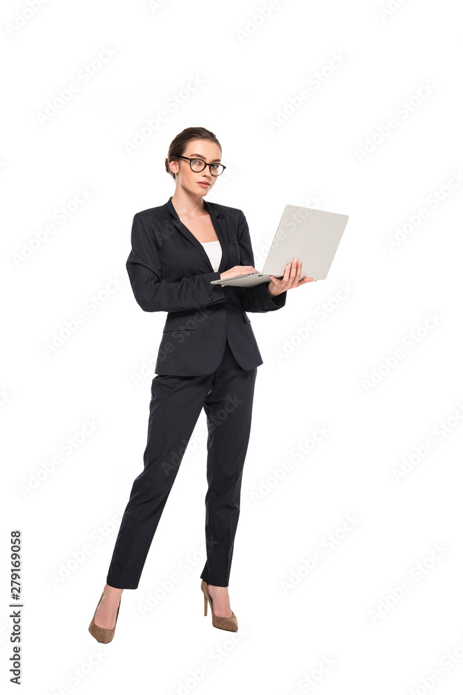 full length view of young successful businesswoman in black suit and glasses with laptop isolated on white full length view of young successful businesswoman in black suit and glasses with laptop isolated on white