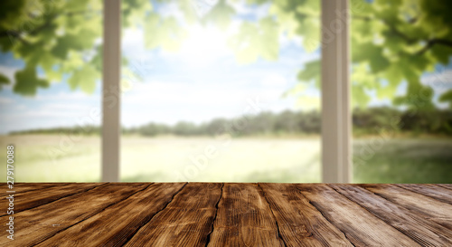 Table top and white window background and beautiful garden forest view in distance. Empty space on the table top for an advertising product.