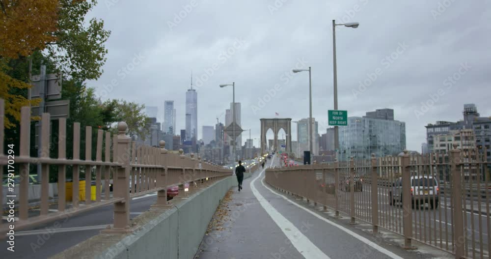 Athletic Man Going On A Run With Incredible Skyscrapers On Classic New York Road Towards Brooklyn Bridge In Beautiful NYC with Autumn Trees Athletic Man Going On A Run With Incredible Skyscrapers On Classic New York Road Towards Brooklyn Bridge In Beautiful NYC with Autumn Trees