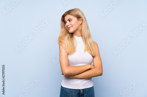 Teenager girl over isolated blue background smiling © luismolinero