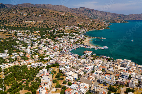 ELOUNDA, CRETE, GREECE - JULY 16 2019: Aerial view of the popular high-end tourist town of Elounda on the Greek island of Crete in the Aegean Sea. © whitcomberd