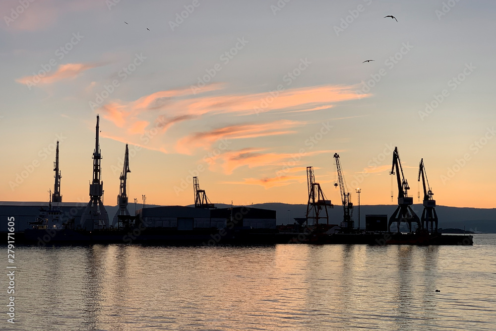 harbor cranes at port at sunset