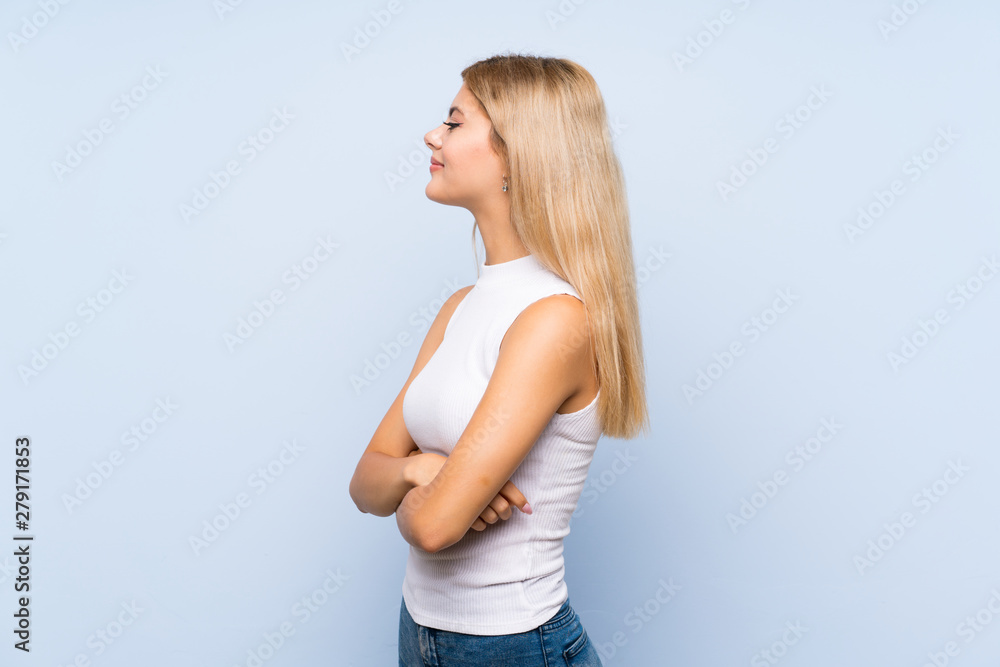 Teenager girl over isolated blue background counting seven with fingers Teenager girl over isolated blue background counting seven with fingers