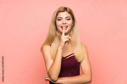 Teenager girl over isolated pink background doing silence gesture