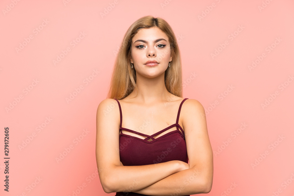 Teenager girl over isolated pink background keeping arms crossed Teenager girl over isolated pink background keeping arms crossed