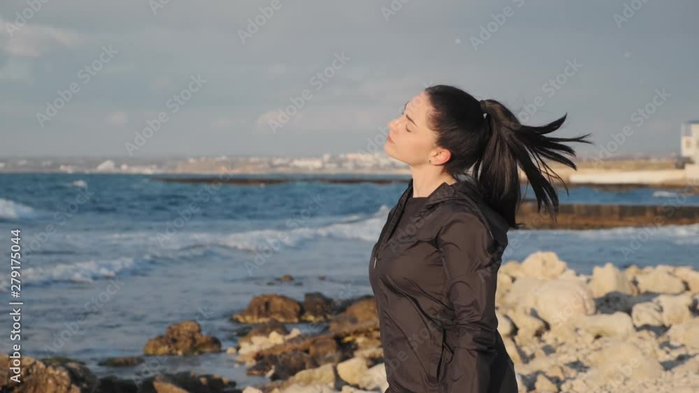 Flexible brunette girl makes side bends on the sea coast slow motion Flexible brunette girl makes side bends on the sea coast slow motion