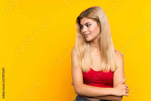 Teenager girl over isolated yellow background thinking an idea © luismolinero