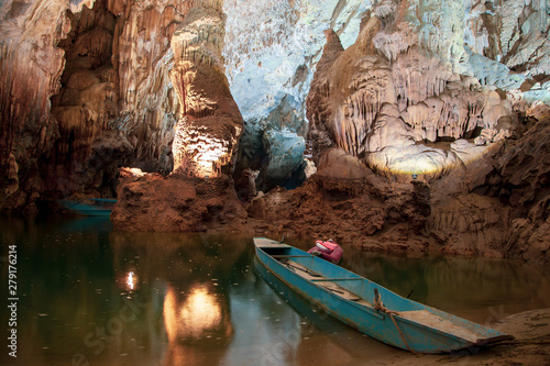 Old blue boat parked inside Phong Nha Cave at Phong Nha National Park in Vietnam. Underground part of the Son River among beautiful stalactites and stalagmites.