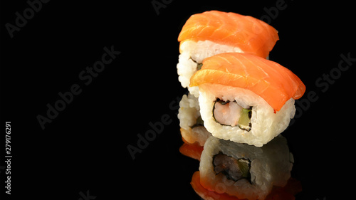 Traditional fresh Japanese sushi rolls. Black background. Reflection. Japanese cuisine. Space for your text.