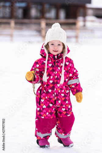 little girl having fun at snowy winter day