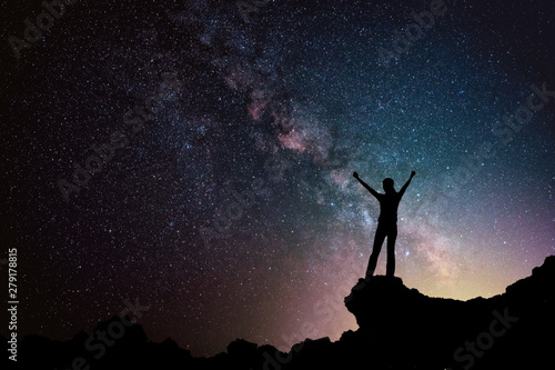 Happy freedom woman on the mountain with starry night sky milkyway. freedom and victory concept.