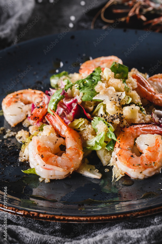Quinoa salad with shrimp and mixed greens in bowls over grey background. Healthy food, clean eating, dieting, top view Quinoa salad with shrimp and mixed greens in bowls over grey background. Healthy food, clean eating, dieting, top view