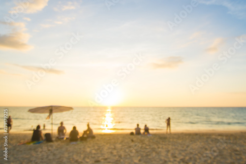 Blurred group of people enjoying sunset on sea beach