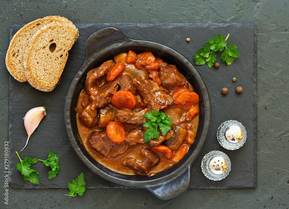 Beef stew in Burgundy. With carrots, onions, peas and champignons in wine. View from above.