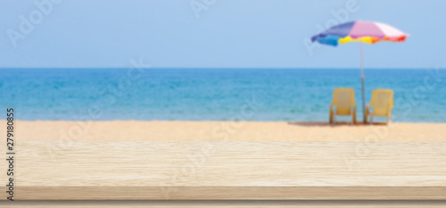 Fototapeta Naklejka Na Ścianę i Meble -  Wooden table top and beach sand for food, drink, vacation product display background, Wood table, desk over blur sea beach background, Wooden shelf, counter and summer sea, product display banner