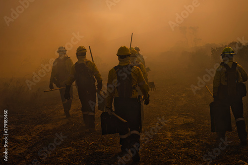 Wildland firefighters walking through smoke photo