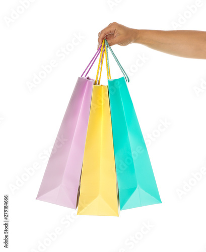Female hand hold color paper bags isolated on white background