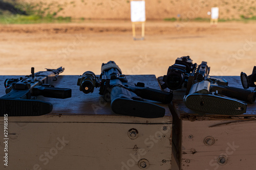Semi-Automatic Rifles laying on bench at outdoor firearms shooting range