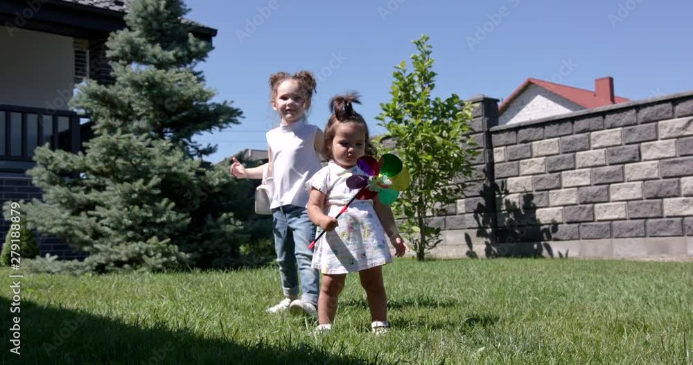 A little girl wears summer clothes with a windmill in her hand